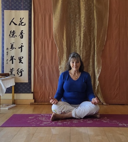 Dorly seated in meditation in her yoga studio
